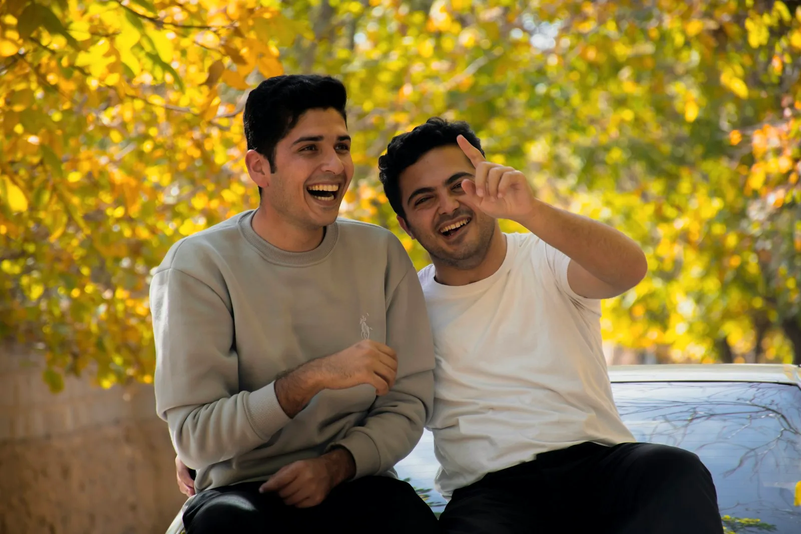 Deux amis qui éclatent de rire en plein air