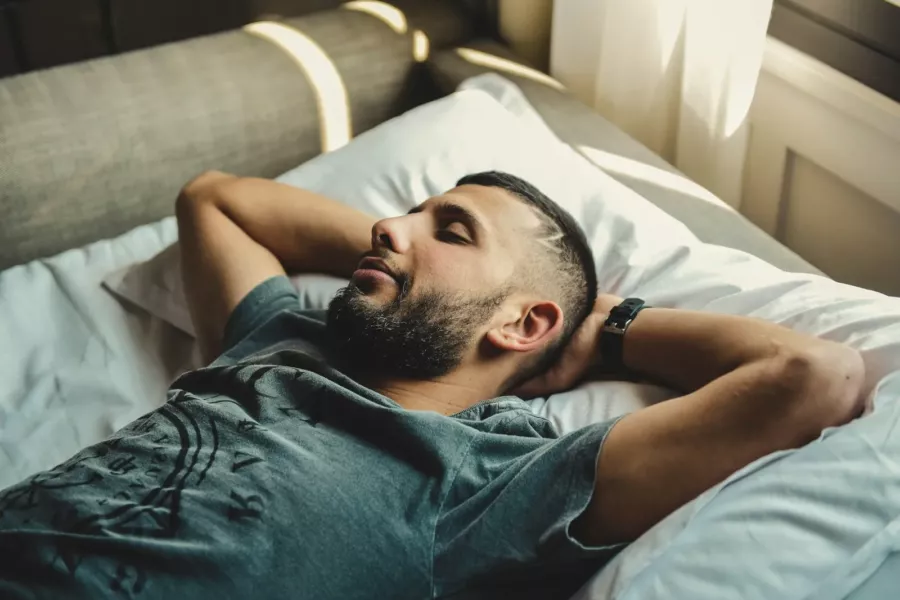 Homme barbu endormi paisiblement dans son lit