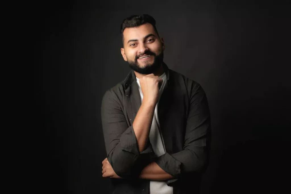 Homme barbu souriant, posture droite et regard assuré