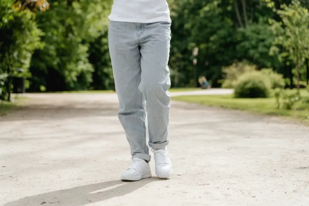 Homme en jean et t-shirt blanc, chaussé de baskets blanches