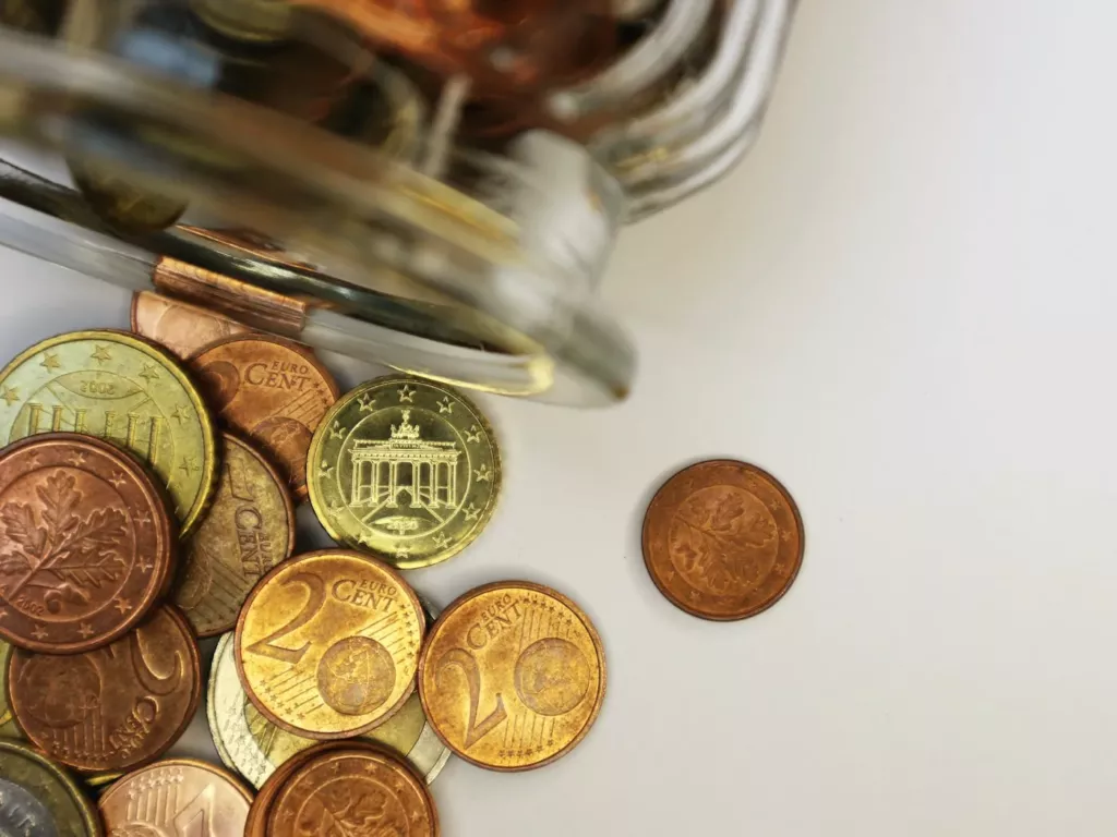 Pièces de monnaie qui s’échappent d’un bocal en verre