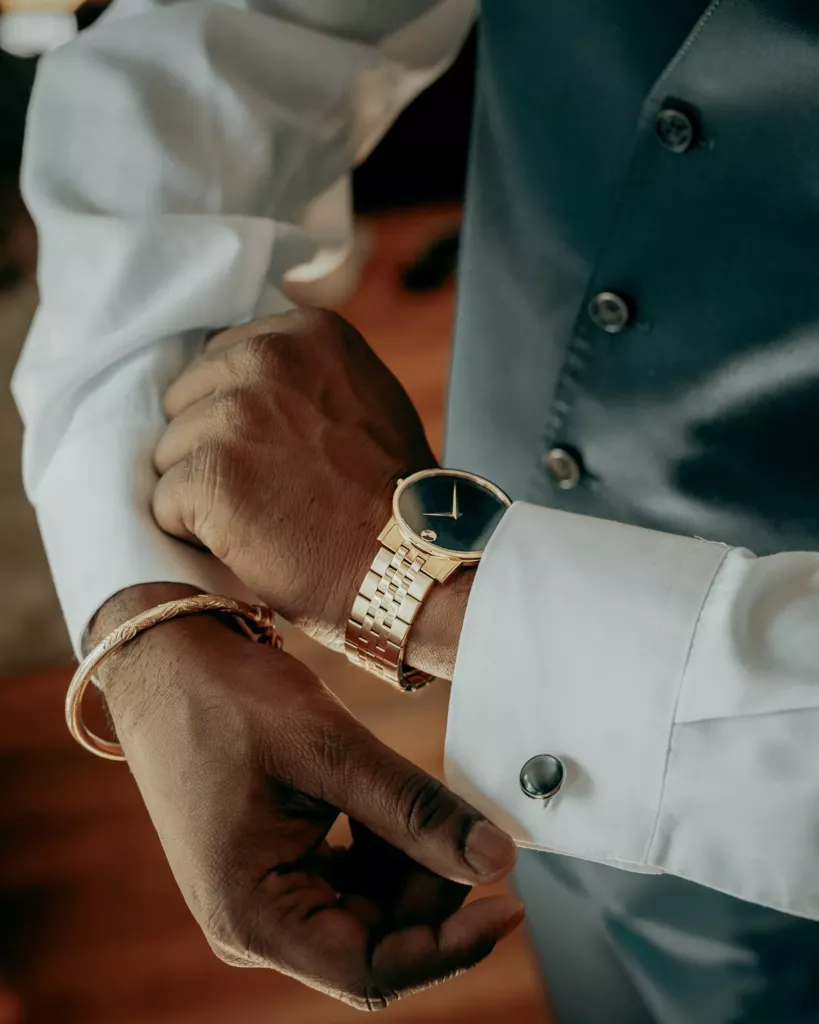 Poignet d’homme avec une montre dorée et des boutons de manchette