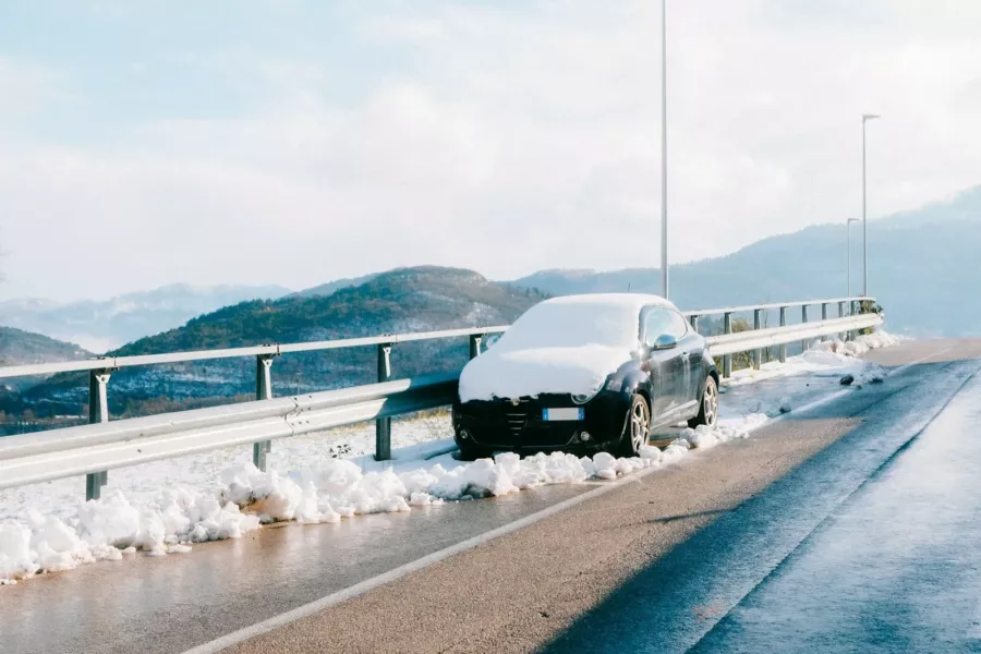 Voiture garée sur une route enneigée de montagne en hiver